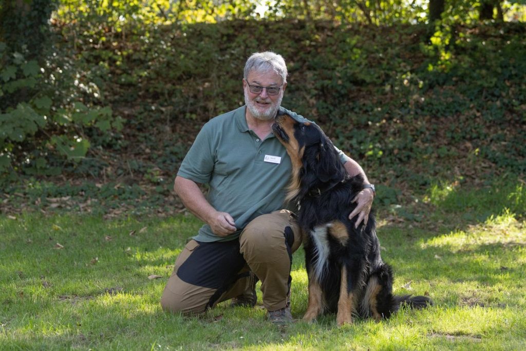 Heimdall stupst Horst auf der Wiese mit der Schnauze an